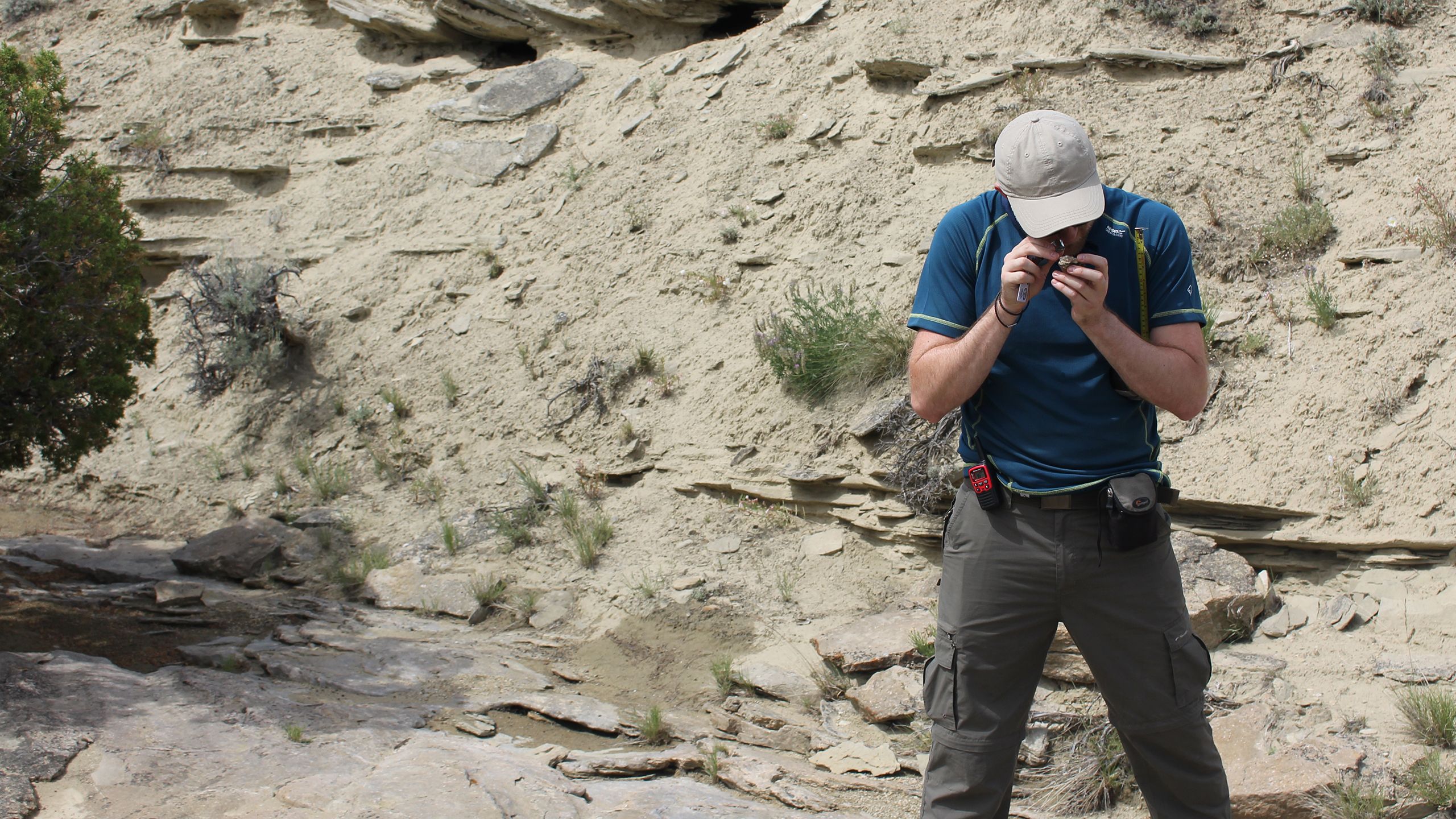 PhD student Joe Bonsor uses a hand lens for a close up look at a rock from the Morrison Formation