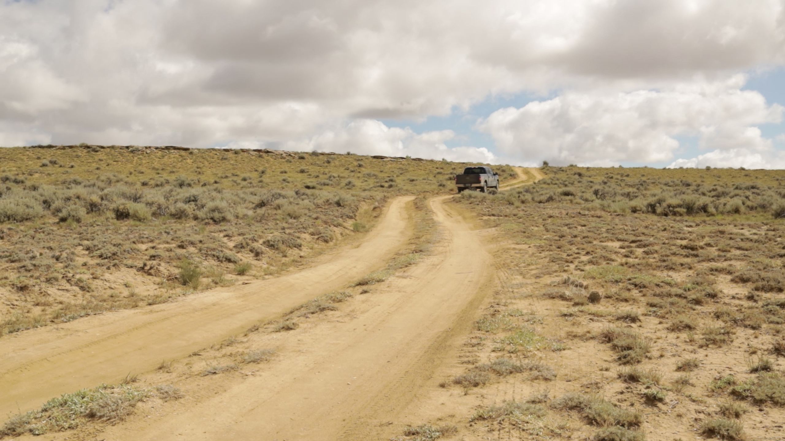 A scrolling time-lapse of a blue truck driving off-road